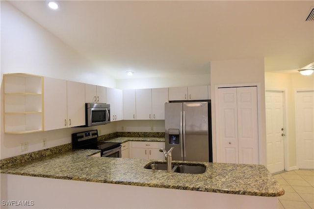 kitchen with dark stone countertops, sink, kitchen peninsula, and appliances with stainless steel finishes