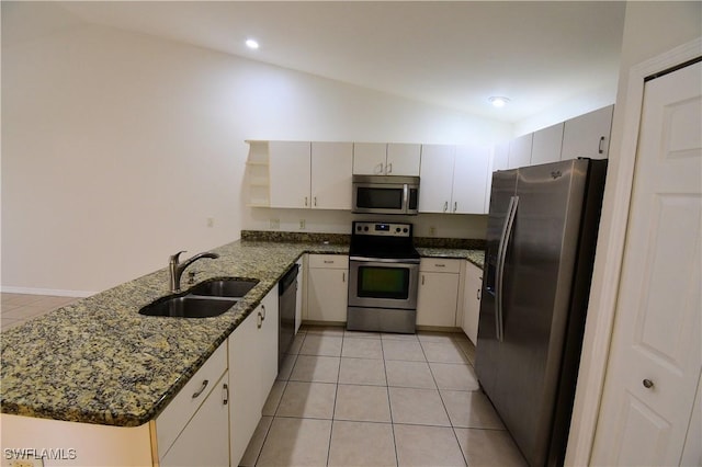 kitchen with sink, white cabinetry, vaulted ceiling, appliances with stainless steel finishes, and kitchen peninsula