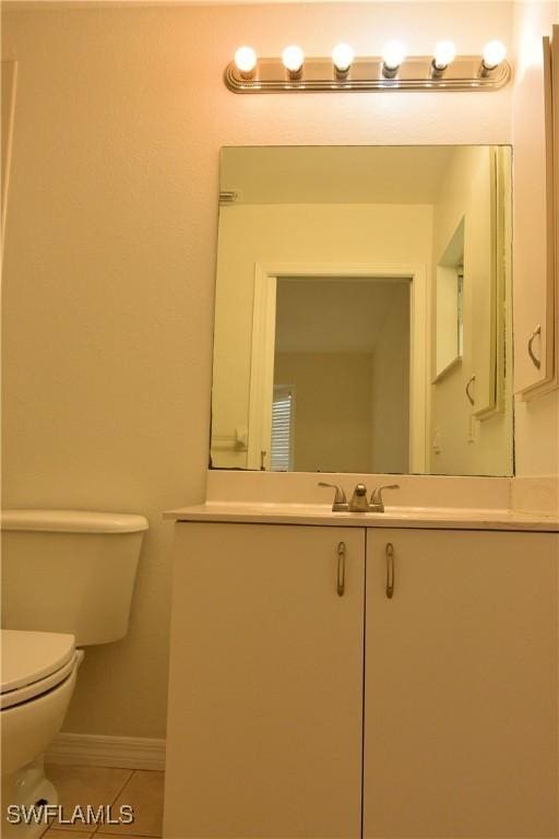 bathroom featuring tile patterned flooring, vanity, and toilet