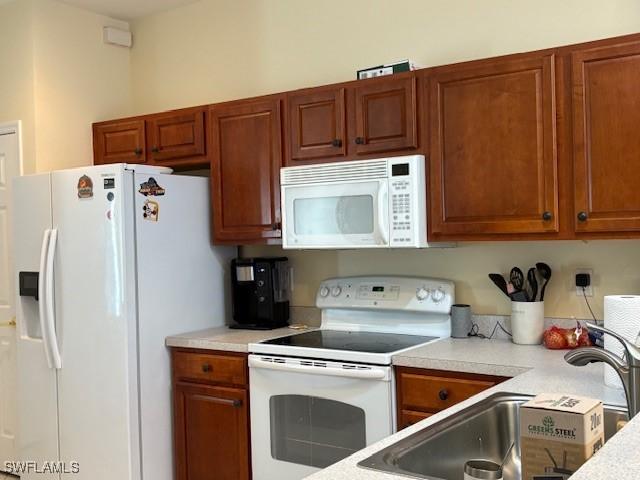 kitchen featuring white appliances and sink