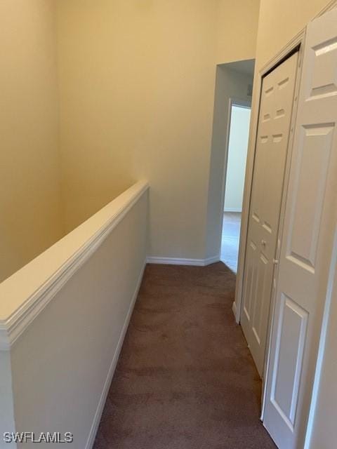 hallway featuring dark colored carpet