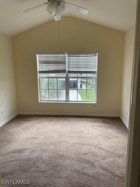 empty room with lofted ceiling, ceiling fan, and carpet