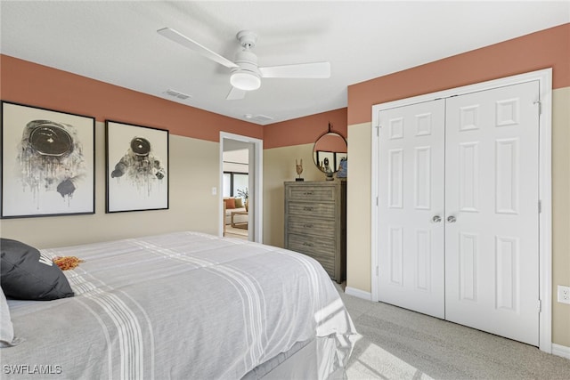 bedroom featuring light colored carpet, a closet, and ceiling fan