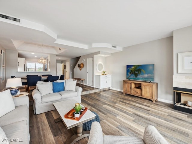 living room with wood-type flooring and a chandelier