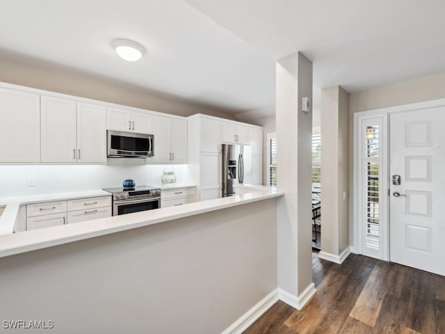 kitchen featuring appliances with stainless steel finishes, dark hardwood / wood-style floors, and white cabinets