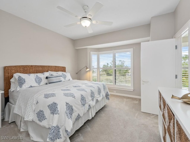 bedroom featuring light colored carpet and ceiling fan