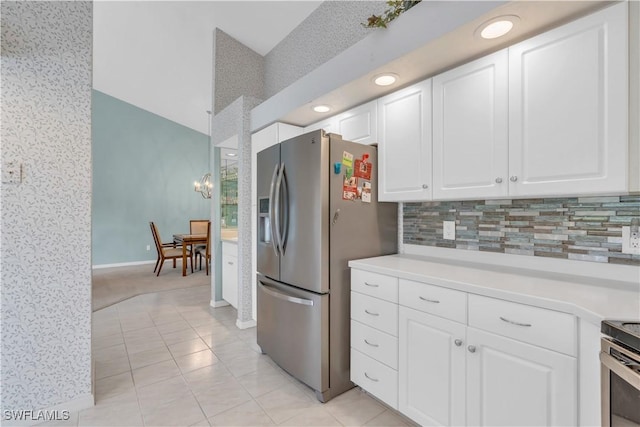 kitchen with light tile patterned floors, stainless steel appliances, backsplash, a chandelier, and white cabinets