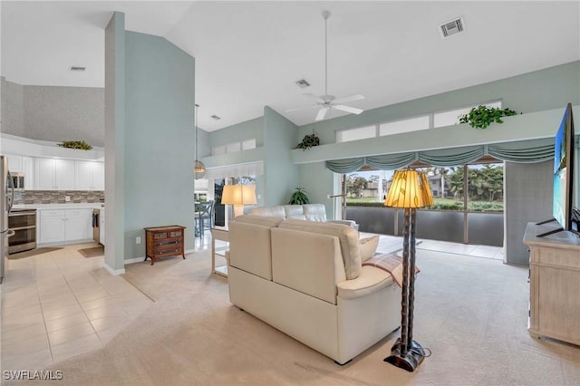 living room featuring high vaulted ceiling, light carpet, and ceiling fan