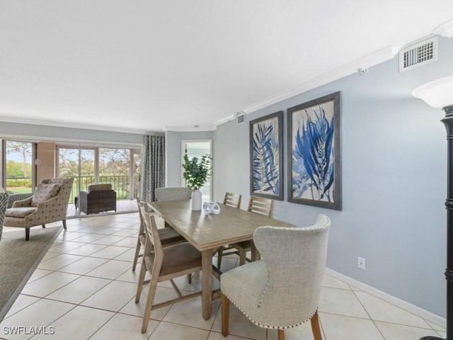 dining area with crown molding and light tile patterned flooring