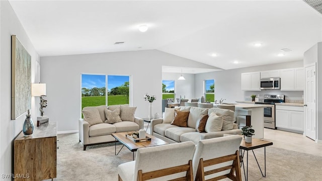 living room featuring sink, light colored carpet, and lofted ceiling