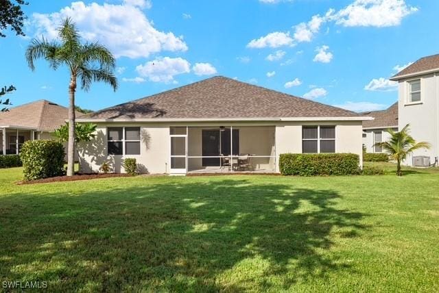 back of property with a yard and a sunroom