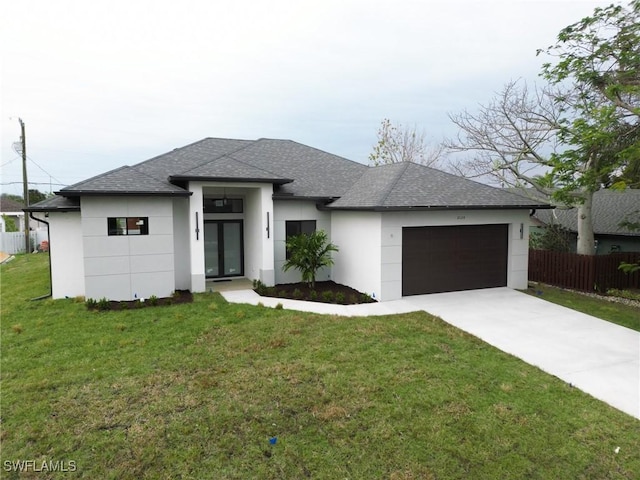 prairie-style house featuring a garage and a front lawn