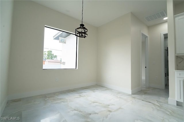 unfurnished dining area with a chandelier