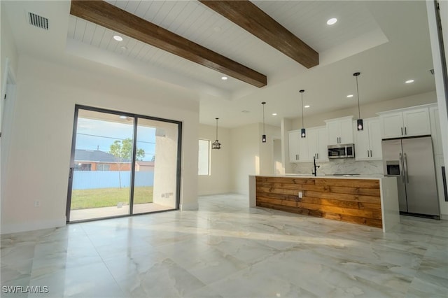 kitchen featuring a spacious island, appliances with stainless steel finishes, pendant lighting, decorative backsplash, and white cabinets