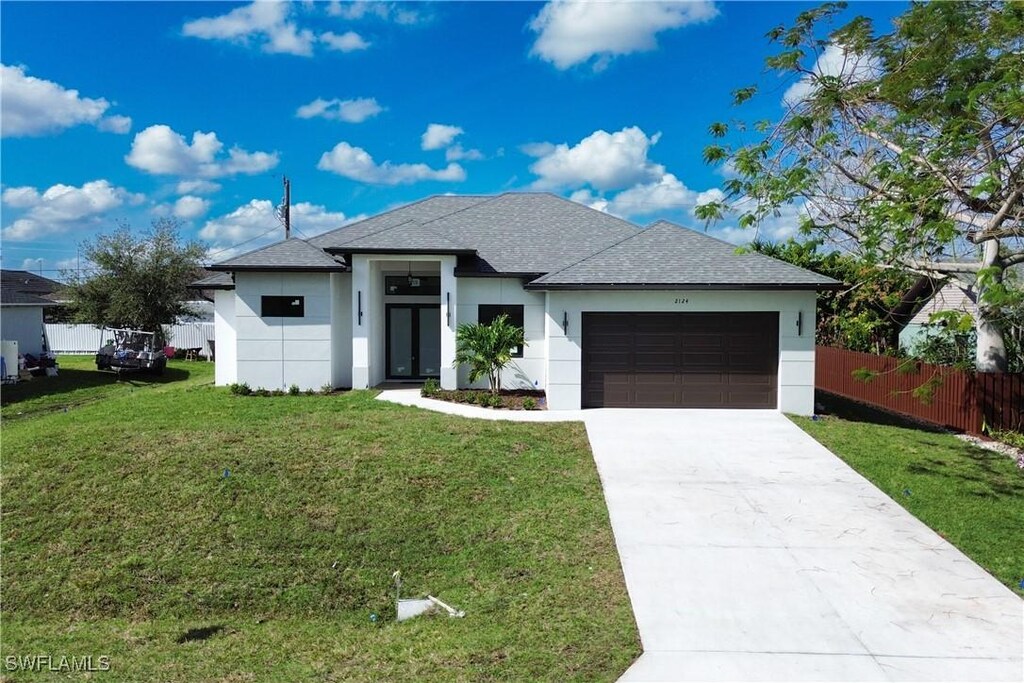 2124 NE 17th Ave, Cape Coral, FL 33909 - view of front of home featuring a garage and a front yard