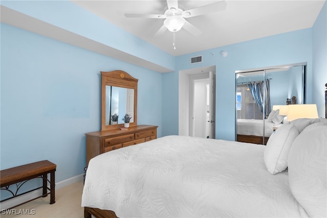 bedroom with ceiling fan, light colored carpet, visible vents, baseboards, and a closet