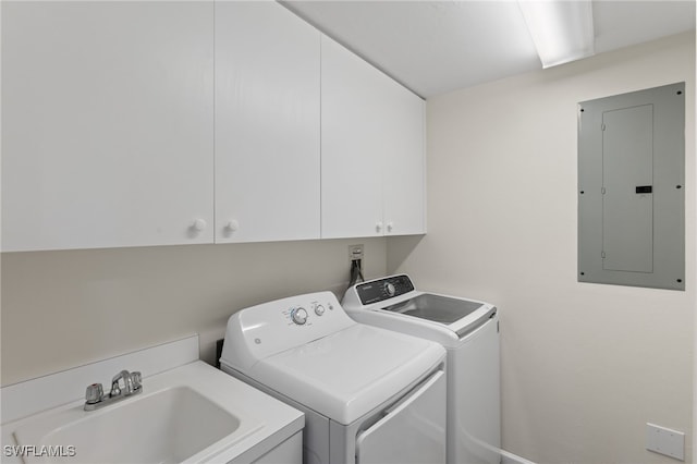 laundry area featuring cabinet space, a sink, electric panel, and washer and dryer