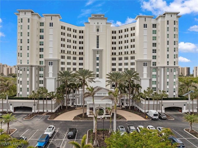 view of building exterior with uncovered parking and a city view