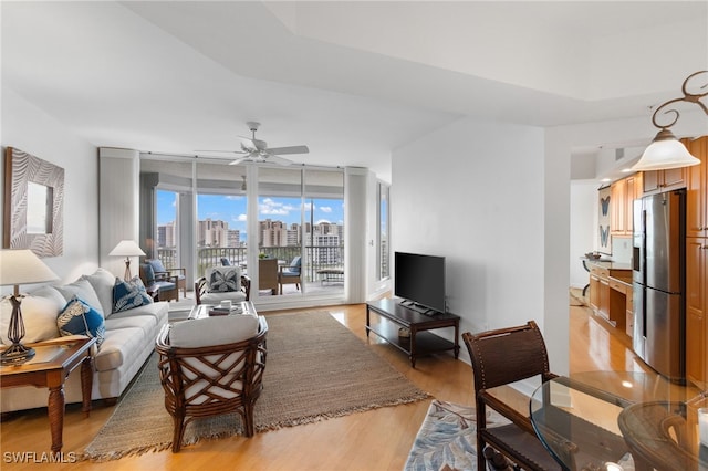 living room featuring floor to ceiling windows, ceiling fan, and light wood finished floors