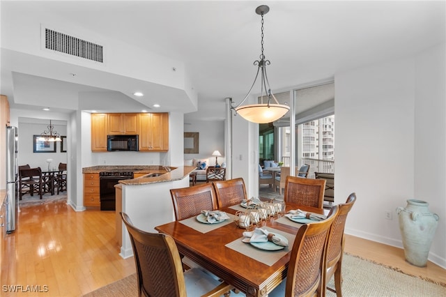 dining space featuring visible vents, baseboards, light wood-style flooring, a chandelier, and recessed lighting