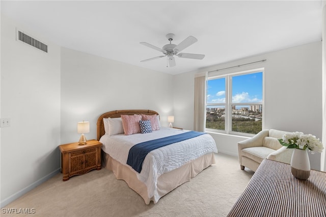 bedroom with baseboards, a ceiling fan, visible vents, and light colored carpet