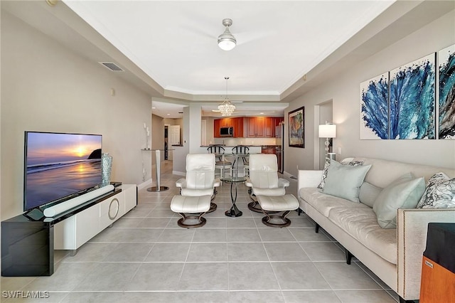 tiled living room featuring a tray ceiling