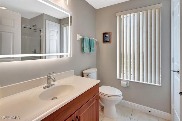bathroom with tile patterned flooring, vanity, toilet, and a shower with shower door