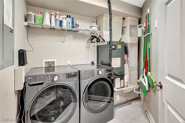 clothes washing area with light tile patterned flooring and washing machine and clothes dryer