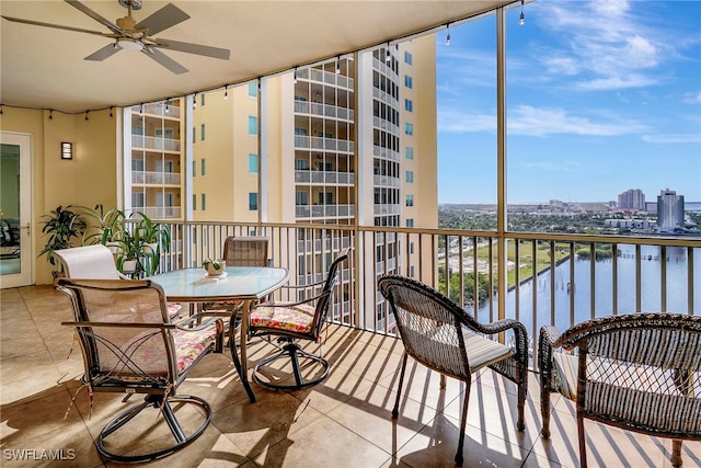 balcony with ceiling fan and a water view