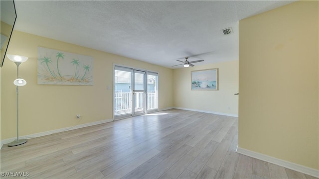 spare room with ceiling fan, a textured ceiling, and light hardwood / wood-style floors