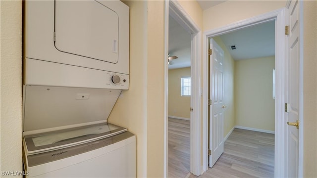 clothes washing area with stacked washer and dryer and light hardwood / wood-style floors