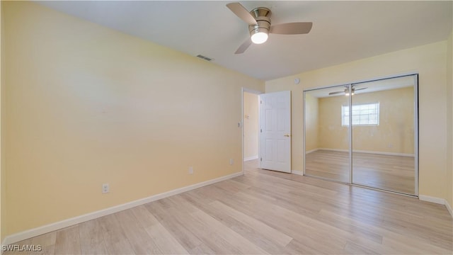 unfurnished bedroom featuring light hardwood / wood-style flooring, ceiling fan, and a closet