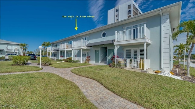 exterior space with a balcony and a front yard