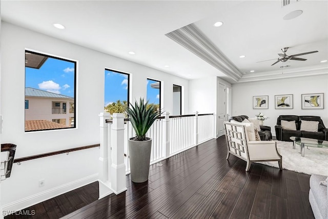 living room featuring crown molding, dark hardwood / wood-style floors, ceiling fan, and a raised ceiling