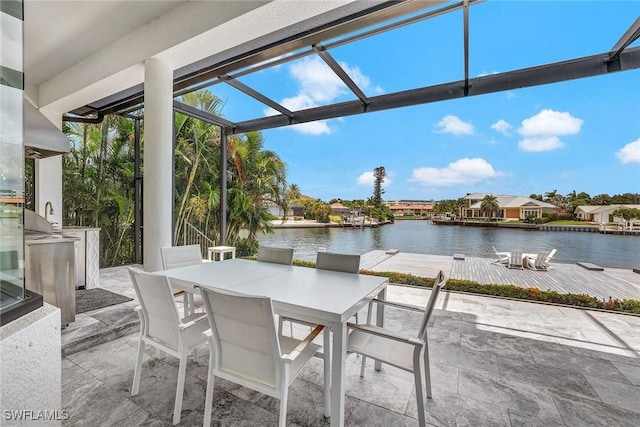 view of patio with a water view and an outdoor kitchen