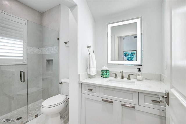 bathroom featuring vanity, toilet, and walk in shower