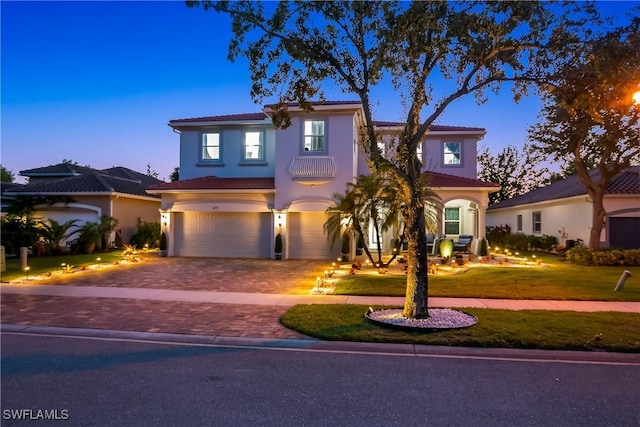 mediterranean / spanish house featuring a garage and a yard