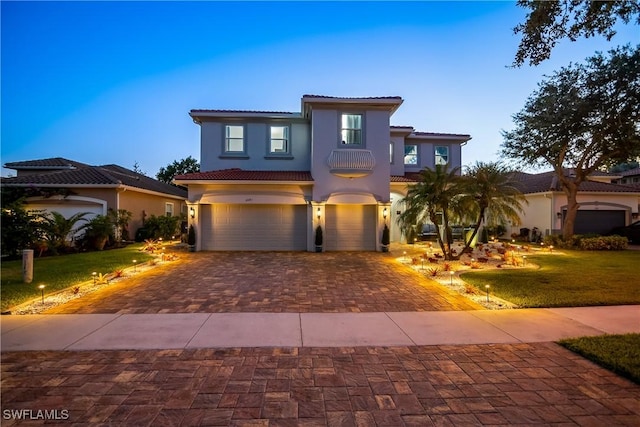 mediterranean / spanish house featuring a garage and a yard