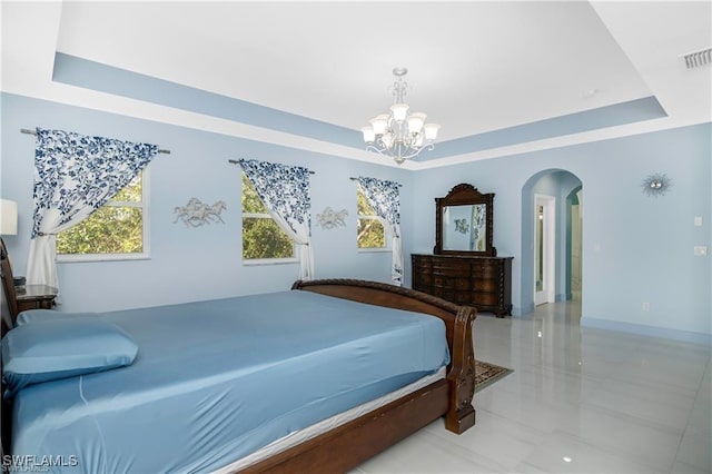 bedroom with a raised ceiling and a chandelier