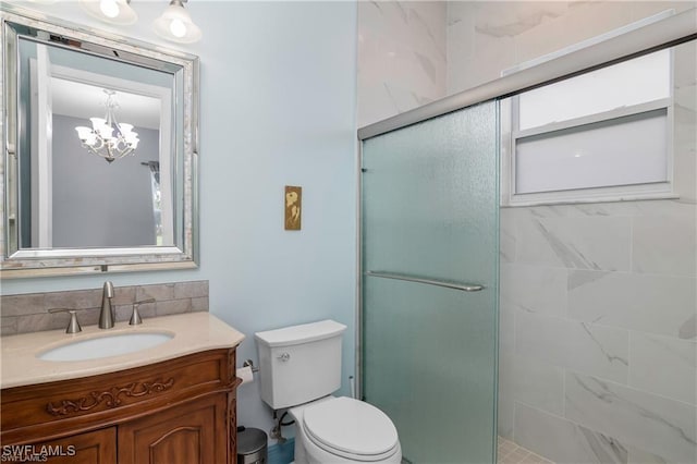 bathroom with tasteful backsplash, toilet, a shower with shower door, and vanity