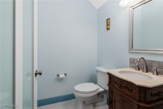 bathroom with toilet, vanity, and tile patterned flooring