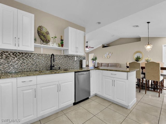 kitchen with dark stone countertops, sink, stainless steel dishwasher, and kitchen peninsula