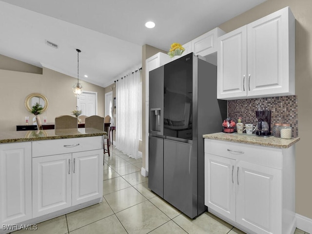 kitchen featuring lofted ceiling, decorative light fixtures, dark stone countertops, and white cabinets