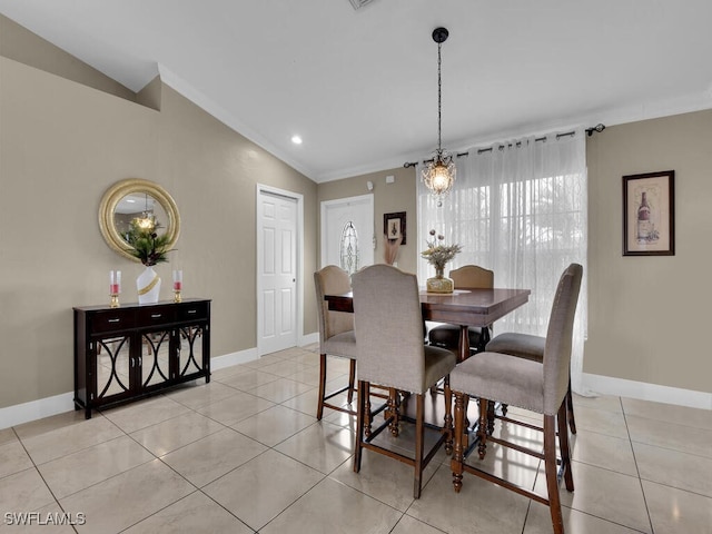 dining area featuring vaulted ceiling, ornamental molding, and light tile patterned flooring