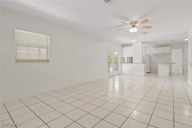 spare room with ceiling fan and light tile patterned flooring