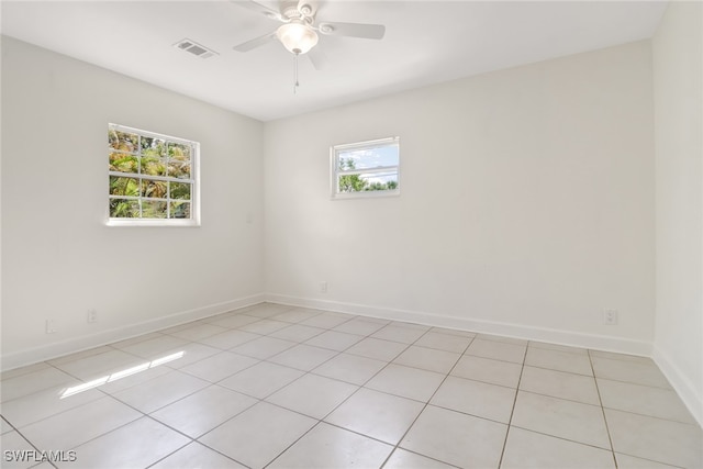 tiled empty room featuring ceiling fan