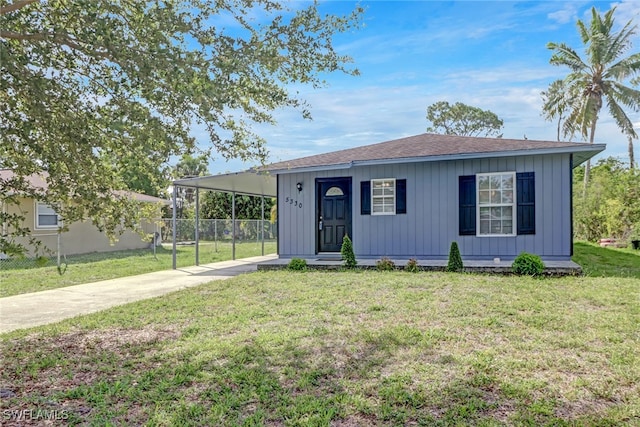 view of front of home with a carport and a front lawn