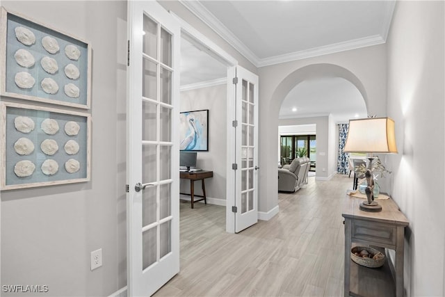 hall with ornamental molding, french doors, and light wood-type flooring