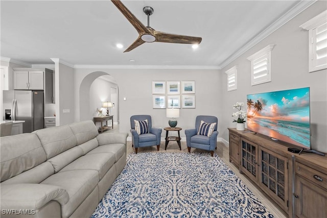 living room featuring crown molding, a healthy amount of sunlight, and light wood-type flooring