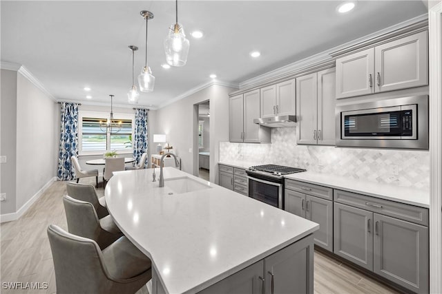 kitchen featuring stainless steel appliances, pendant lighting, sink, and gray cabinetry